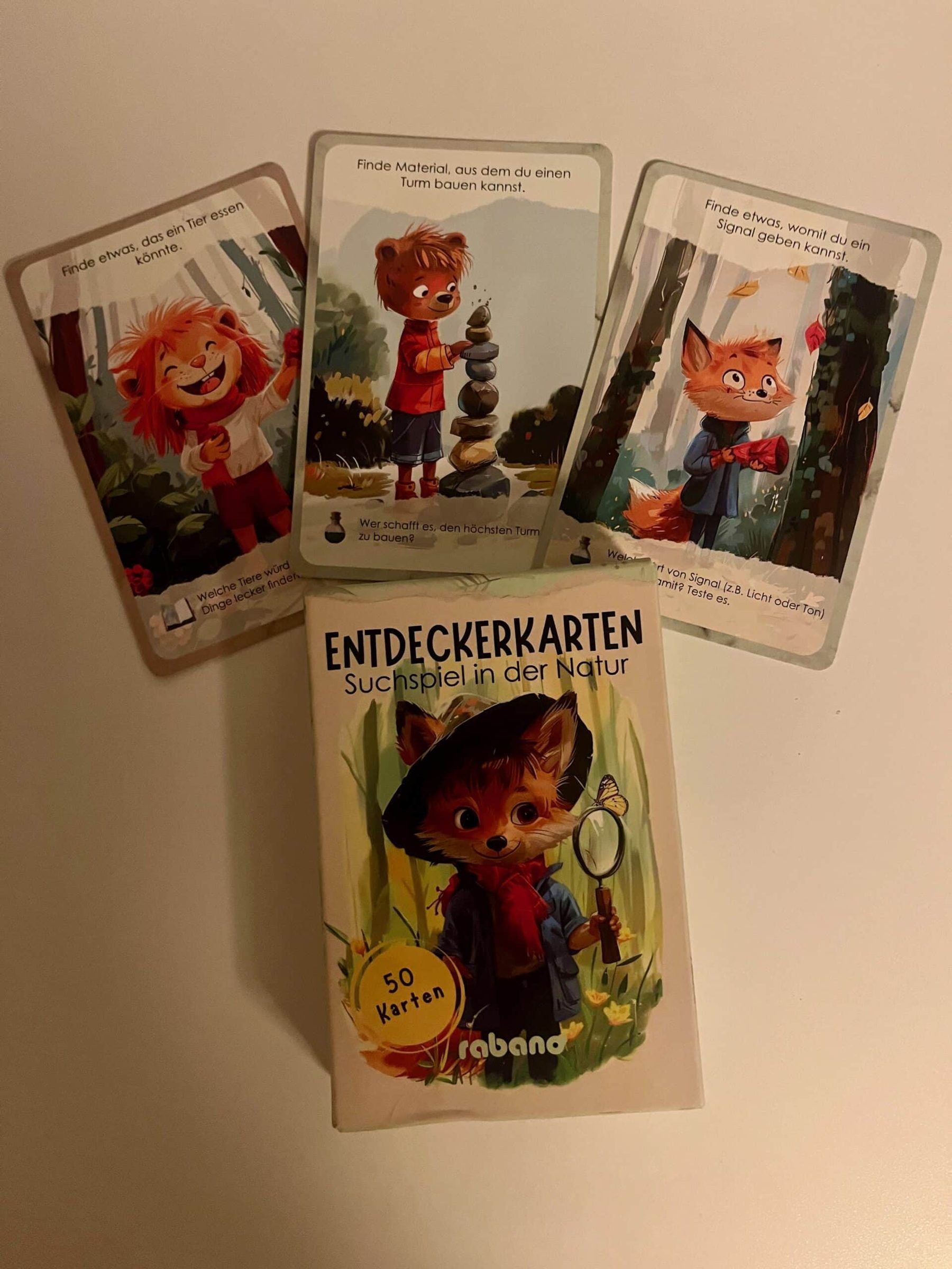 Illustrierte Entdeckerkarten mit Fuchs und Waldtieren, ausgelegt auf einem Tisch