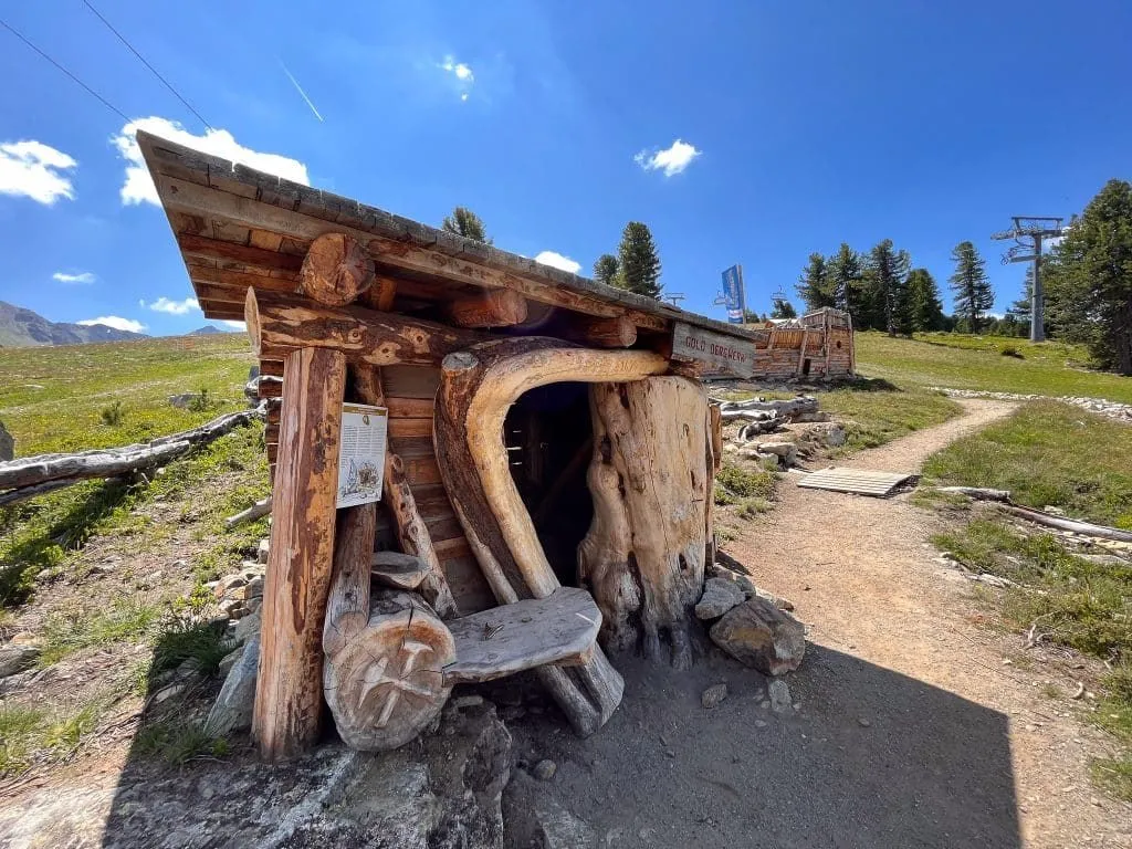 Geschnitzte Holzhütte am Wegrand
